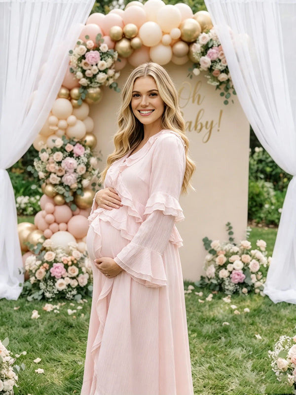 Side view of light pink chiffon maternity maxi dress with ruffled V-neck, tiered ruffle bell sleeves and high-low ruffle hem, designed for baby shower.