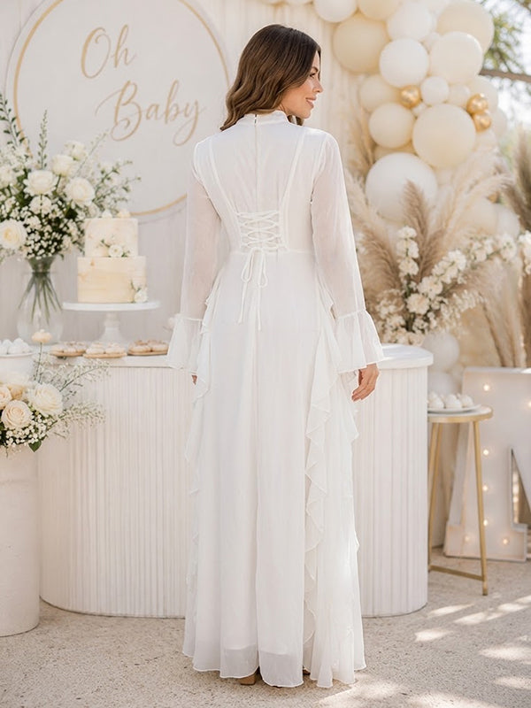 Back view of white chiffon maternity maxi dress with mock neck, bell sleeves and side ruffles, designed for baby shower.