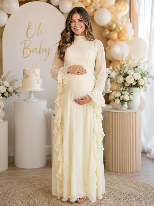 Pale yellow chiffon maternity maxi dress with mock neck, bell sleeves and side ruffles, designed for baby shower.