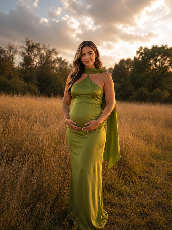 Chartreuse green satin maternity maxi dress with halter neck and long trailing scarf, designed for maternity photoshoot.