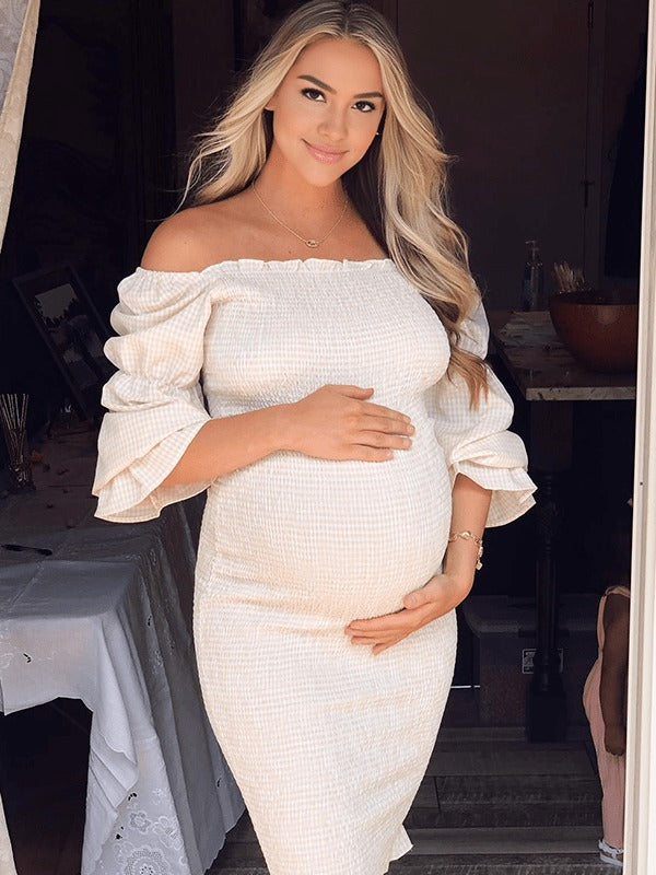 Ivory smocked maternity midi dress with off-shoulder neckline and puff sleeves, designed for baby shower.