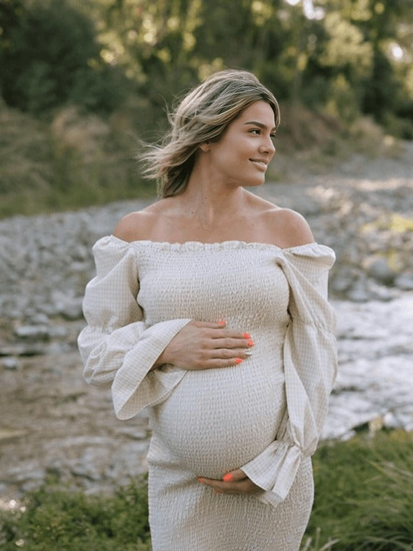 Ivory smocked maternity midi dress with off-shoulder neckline and puff sleeves, designed for baby shower.