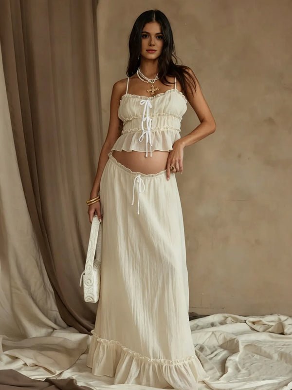 Ivory maternity two-piece set with smocked ruffle cami crop top and drawstring ruffle-hem maxi skirt, designed for maternity photoshoot.