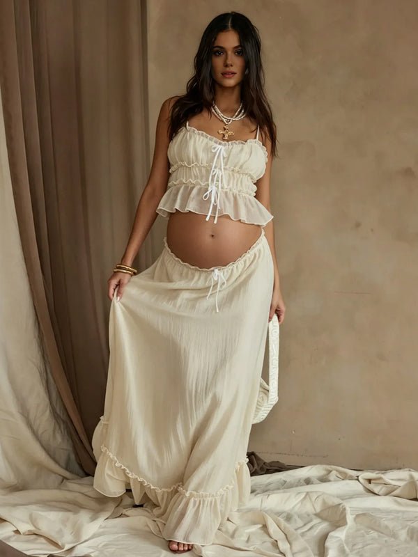 Ivory maternity two-piece set with smocked ruffle cami crop top and drawstring ruffle-hem maxi skirt, designed for maternity photoshoot.