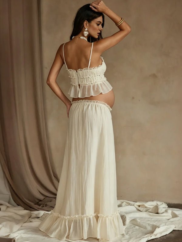 Back view of ivory maternity two-piece set with smocked ruffle cami crop top and drawstring ruffle-hem maxi skirt, designed for maternity photoshoot.