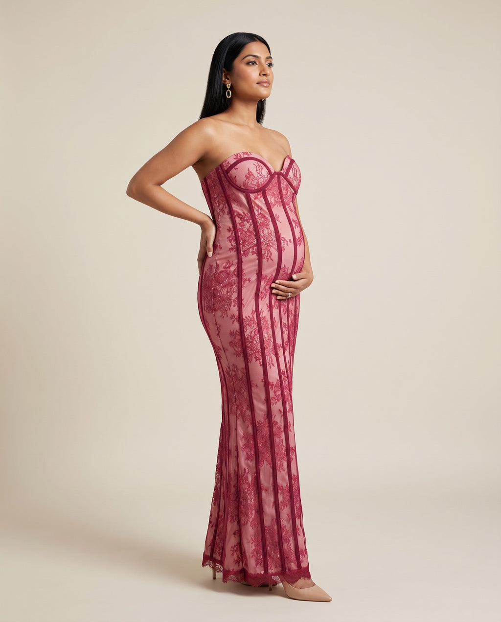 Red lace maternity maxi dress with strapless corset bodice and flowing skirt, designed for evening maternity photoshoots.