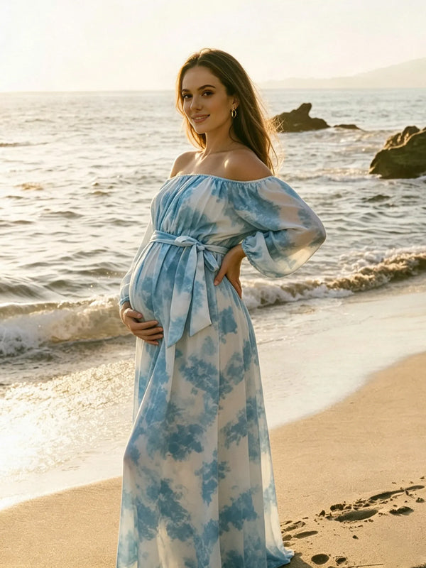 Blue tie-dye chiffon maternity maxi dress with off-shoulder neckline, balloon sleeves and tie waist, designed for photoshoot and baby shower.