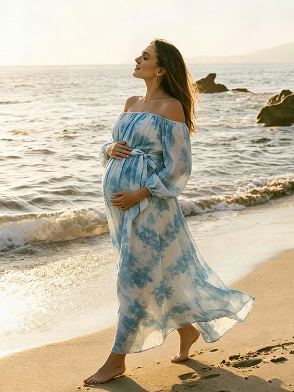 Side view of blue tie-dye chiffon maternity maxi dress with off-shoulder neckline, balloon sleeves and tie waist, designed for photoshoot and baby shower.