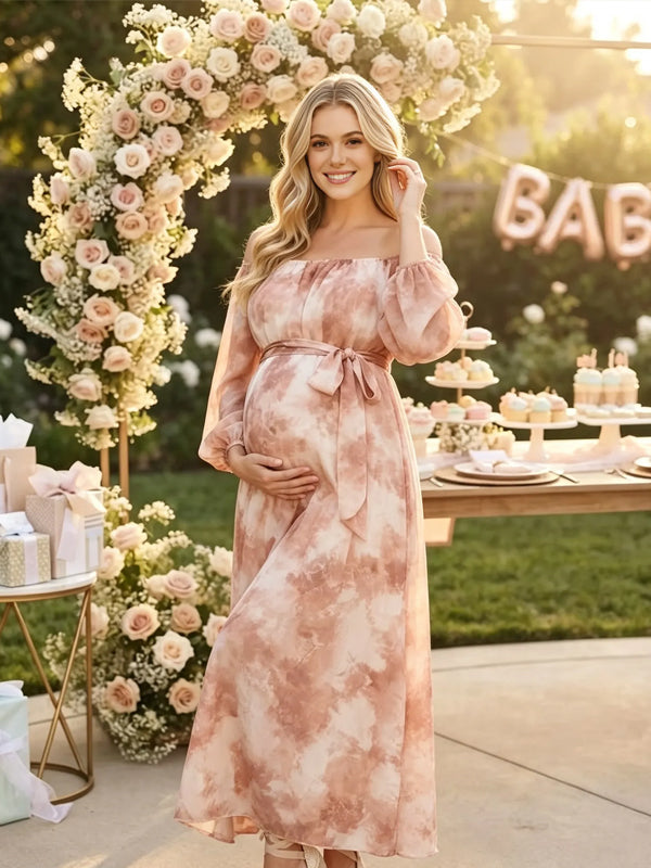 Coral pink tie-dye chiffon maternity maxi dress with off-shoulder neckline, balloon sleeves and tie waist, designed for photoshoot and baby shower.