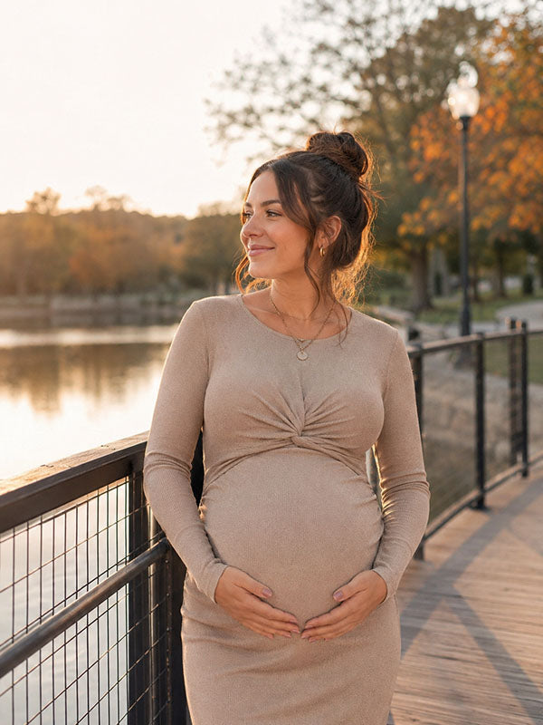 Beige knit maternity midi dress with twist front and long sleeves, designed for maternity photoshoot.
